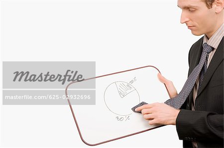 Side profile of a businessman rubbing a pie chart with his tie