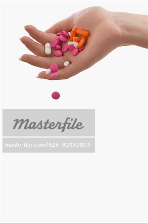 Pills falling from a person's hand