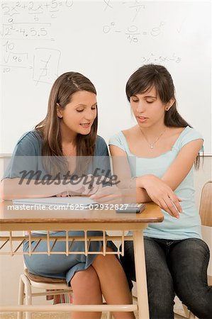 Female teacher talking to her student in a classroom