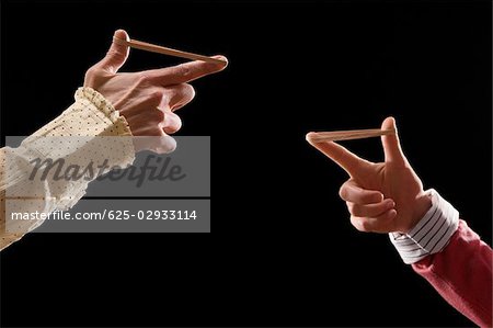 Close-up of business people's fingers stretching rubber bands