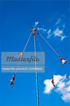 Low angle view of totonac voladores flying dancers flying from the pole, El Tajin, Veracruz, Mexico