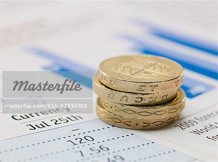 One pound coins and and financial papers