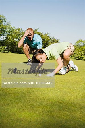 Golfspieler, die versuchen, Schlag-Golf-Ball in Loch