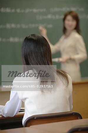 Rear view of high school girl studying