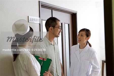Female nurse, doctor and patient talking