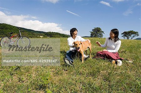 Junges Paar mit Hund spielen