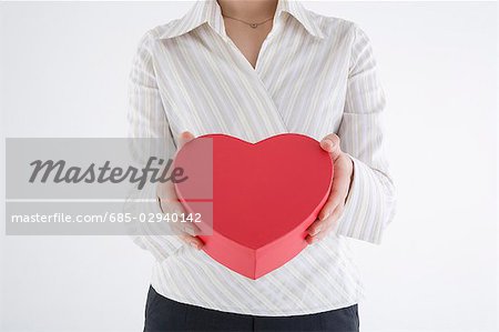 Geschäftsfrau hält Heart-shaped box