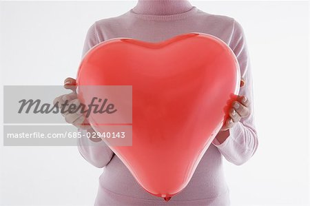 Woman holding heart-shaped balloon