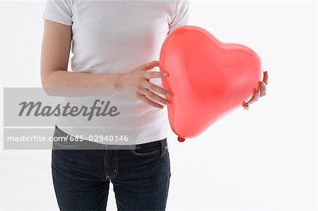 Woman holding heart-shaped balloon