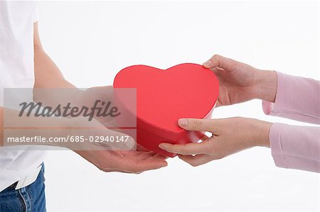 Femme donnant la boîte en forme de cœur de l'homme