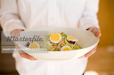 Young woman holding bowl of salad