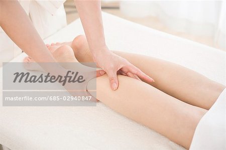 Massage therapist applying foot massage