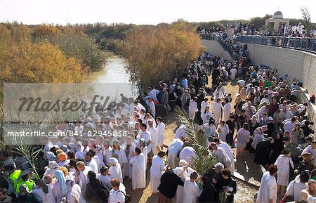 Crowds of pilgrims in white dress queueing to enter the water of the Jordan River during Christian Orthodox ceremony at Epiphany, Qasr el Yahud, Israel, Middle East