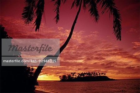 Silhouettes des palmiers et une île déserte au lever du soleil, Rarotonga, îles Cook, Pacifique Sud, Pacifique