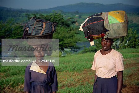 Lourdes charges de linge à bord de tête à laver dans la rivière, Ouganda, Afrique de l'est, Afrique