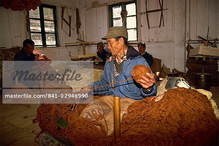 Portrait d'un homme tibétain filage de la laine dans une fabrique de tapis dans un centre d'entraide à Darjeeling, Inde, Asie