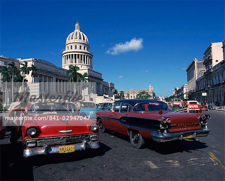Street scene of old American automobiles used as taxis parked near the Capitolio Building in Central Havana, Cuba, West Indies, Central America