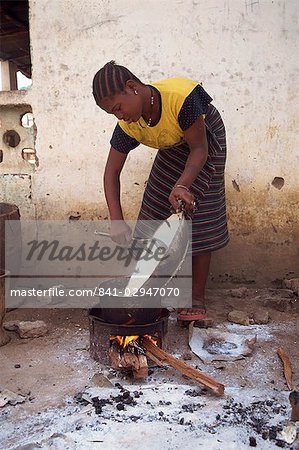 Portrait of a woman cooking outdoors over a small fire, Gambia, West Africa, Africa