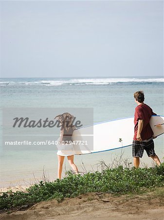 Paar, gehen an den Strand zum Surfen