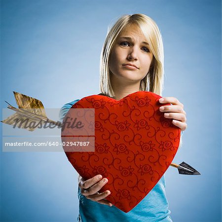woman holding up a heart with an arrow through it