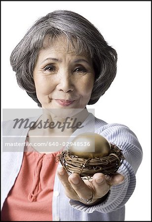 senior woman holding a golden egg