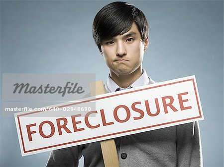 man holding a foreclosure sign