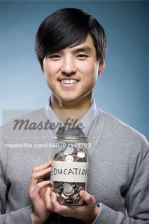 man holding a jar of coins