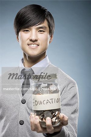 man holding a jar of coins