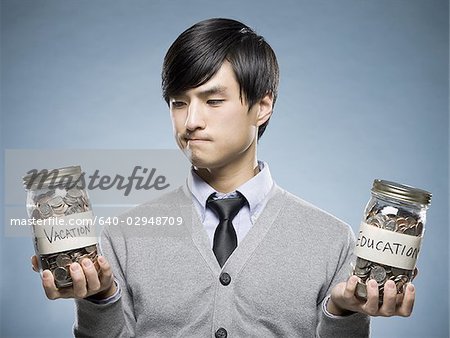 man holding two jars of coins