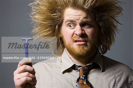 homme avec des cheveux fous, tenant un rasoir