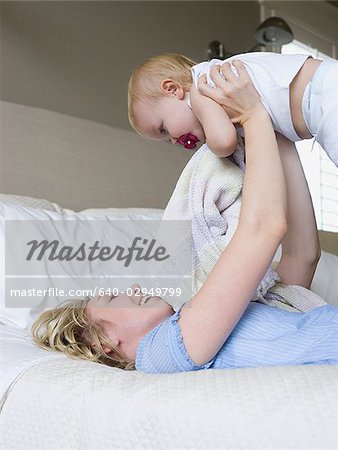 woman lying on a bed with her baby girl