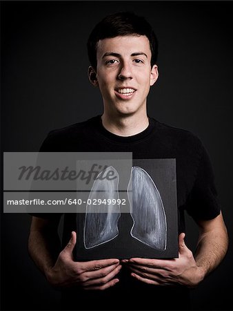 man holding up a drawing of lungs in front of his chest