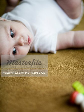 baby girl lying on the carpet