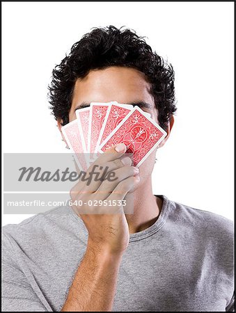homme couvrant son visage avec cartes à jouer