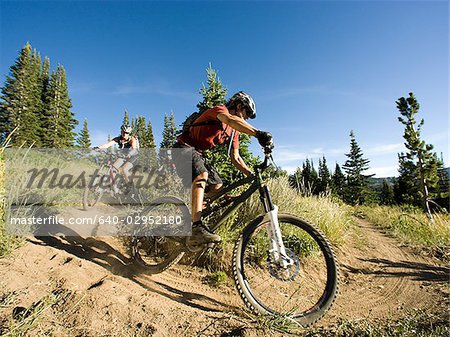 mountain bikers riding down a trail