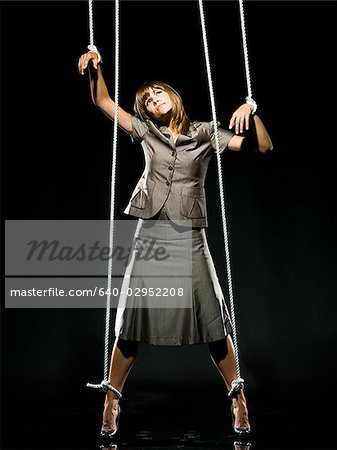 businesswoman being pulled by strings like a puppet