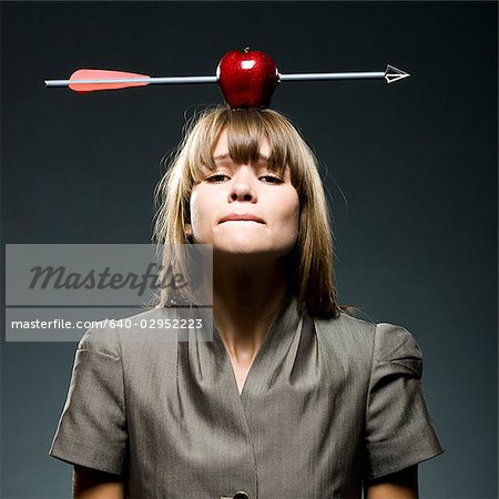 businesswoman with an apple with an arrow through it on her head