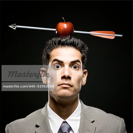 homme d'affaires avec une pomme sur la tête qui a été tournée avec une flèche