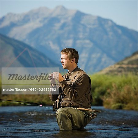 Fly fisherman pêcher dans une rivière de montagne