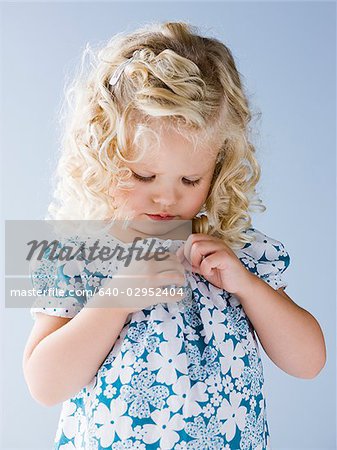 little girl buttoning her shirt