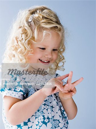 little girl holding up three fingers