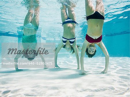 Jugendliche in einem Schwimmbad machen Handstand unter Wasser