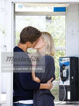 couple s'embrassant dans une cabine téléphonique