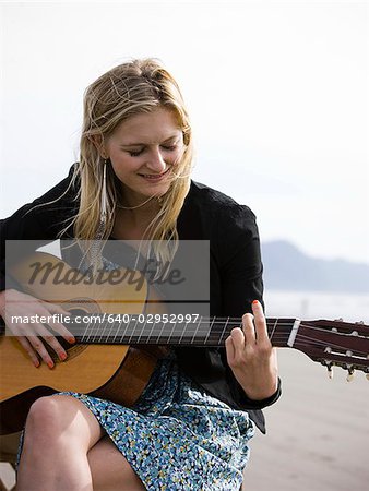 femme à la guitare à la plage