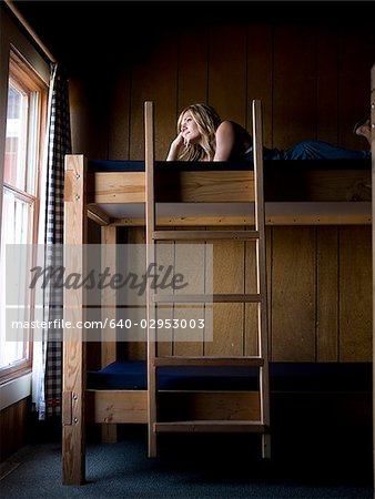 woman lying on the top bunk of a bunk bed