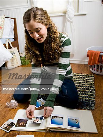 woman sitting on the floor scrapbooking in her room