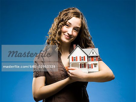 femme tenant une maison miniature