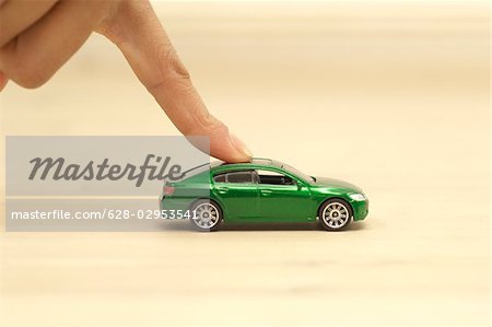 Finger pushing green toy car