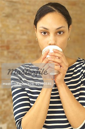 Serious young woman holding plastic cup