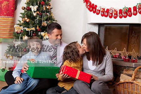 Familie mit zwei Kindern am Weihnachtsbaum